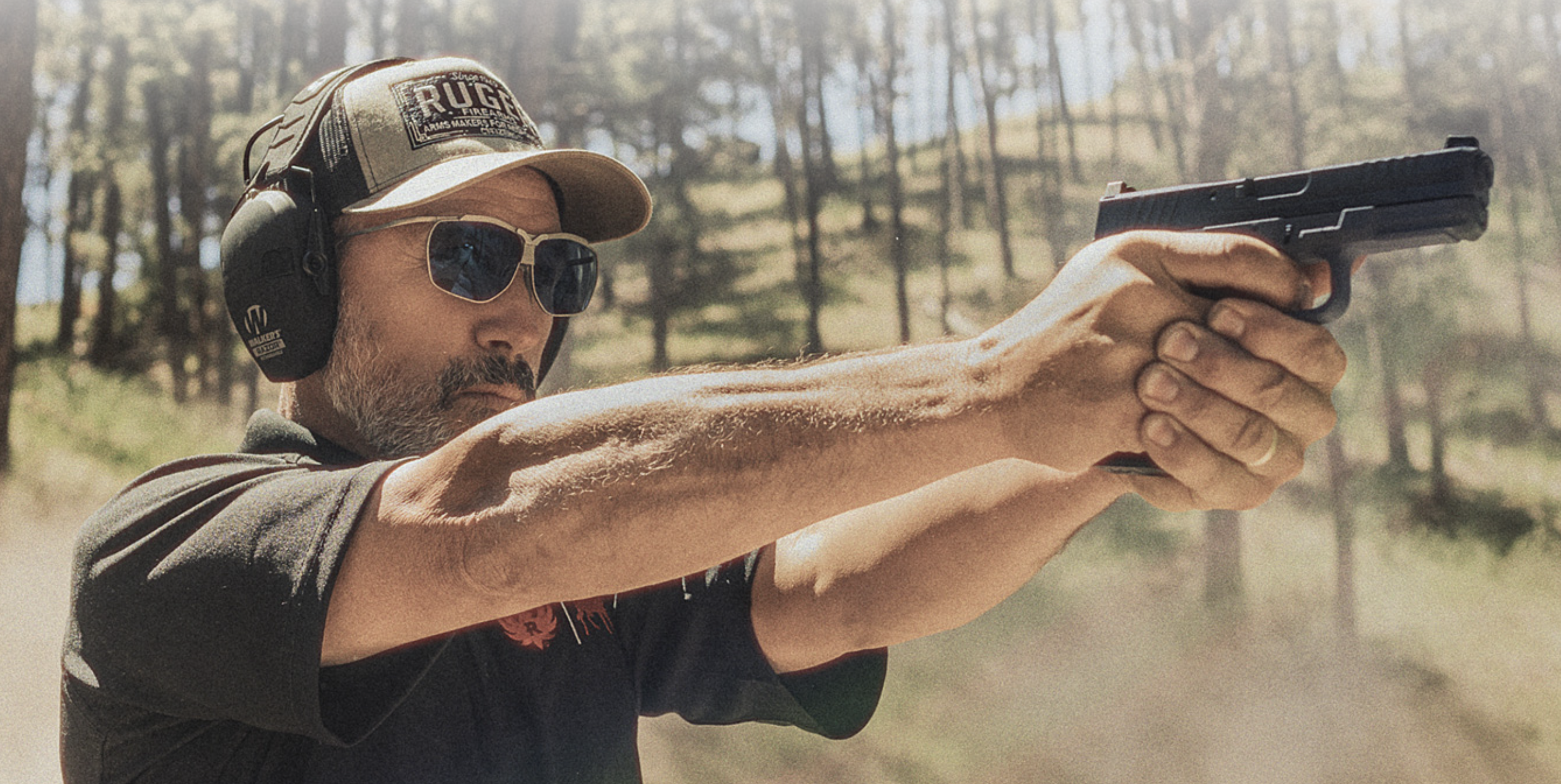 Man on gun range firing Ruger RXM 9mm pistol